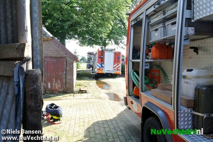 Brandweer bevrijdt koe uit benarde positie Vossersteeg - Foto: Niels Jansen