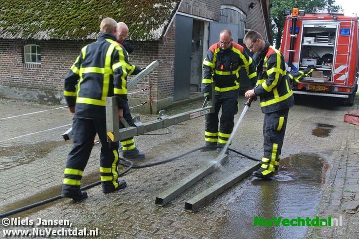 Brandweer bevrijdt koe uit benarde positie Vossersteeg - Foto: Niels Jansen